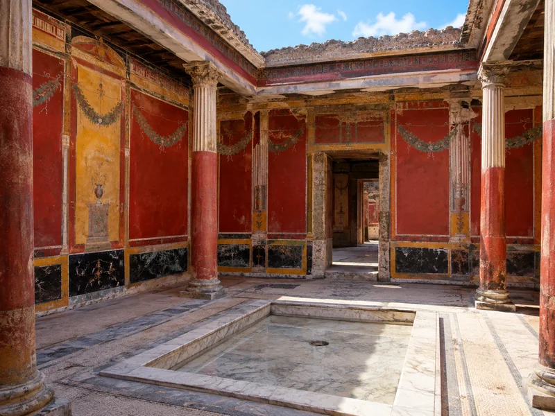 Rot und ocker bemalte Wände im Atrium einer Villa in Pompeji